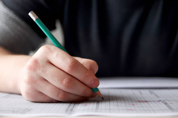 istock Architect working on a drawing project, hand with pencil on graph paper, close-up. Close-up of hand sketching on graph paper 2162225267
