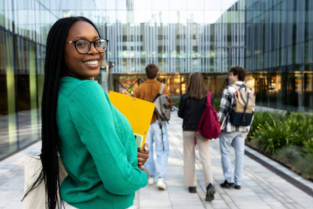istock African American female college student looking back at camera while walking to class with friends. Copy space. 2162226279