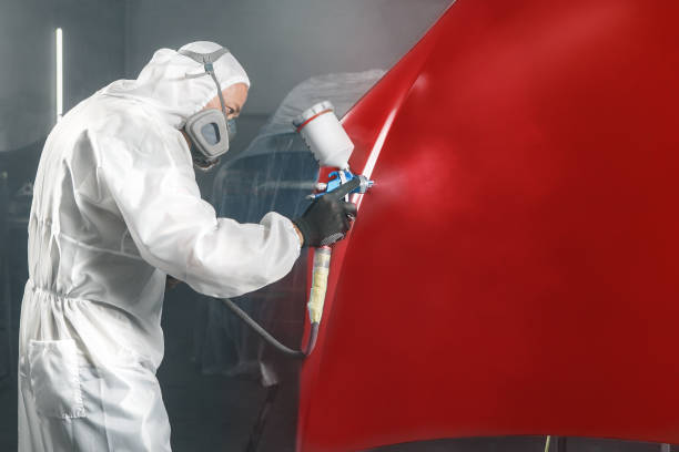 istock Professional car painter in chamber paints automobile bonnet. 2162226285