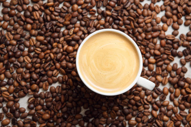 istock Freshly Brewed Cup of Latte Surrounded by Roasted Coffee Beans 2162229897