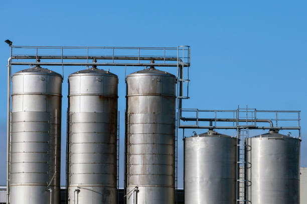 istock Shiny metal tanks placed in a row under clear blue sky 2162230662