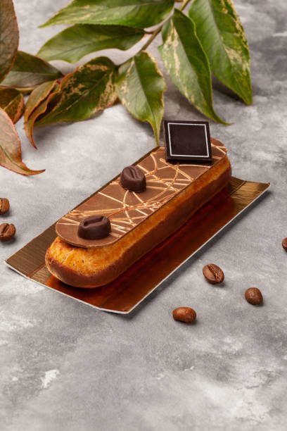 istock Chocolate glazed eclair with coffee custard on gold cardboard 2162230747