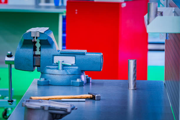 istock Vice is fixed on a metal table. Vise in a carpentry workshop. Table in a car workshop. Hammer lies next to the tees. Concept - equipment for a car workshop. Workplace car mechanic. Sale vise. 2162235802