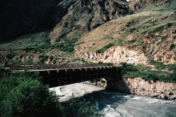 Wooden old bridge above canyon mountain stream