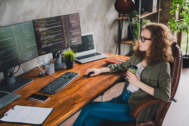 istock Photo of confident successful woman software developer sitting drinking tea comfortable workspace workstation indoors 2162237733