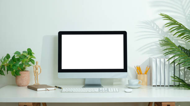 istock Modern desktop compute books and cup of coffee on white table. Blank screen for your advertising text message. 2162240550