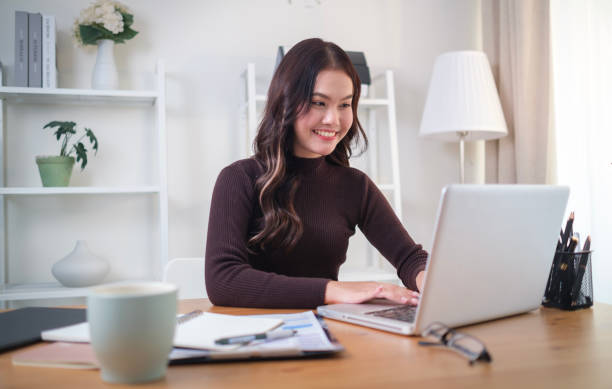 istock Charming young woman working with laptop while sitting at comfortable workplace. 2162242211