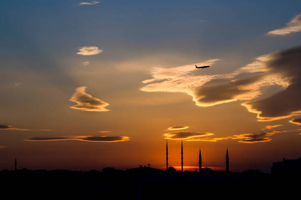 Small passenger plane in silhouette on the blue sky with sunset colors