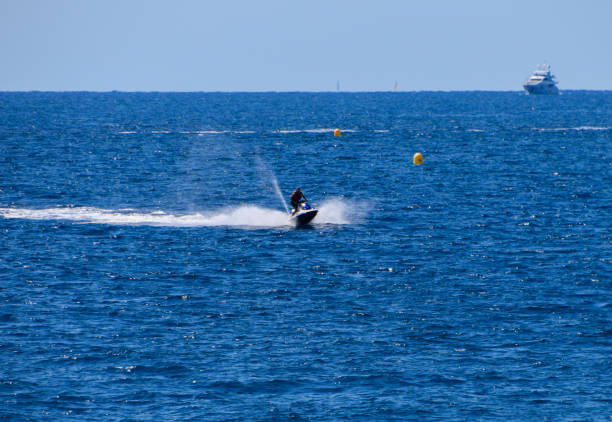 This image is from Gokarna City, State Karnataka Country India, on 16th May 2024A man is riding a jet ski in the ocean. The water is calm and the sky is clear