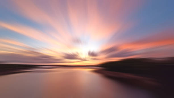 Romantic sunset sky background with smooth rushing clouds and soft wave water on the beach.