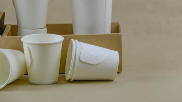 istock White paper coffee cup, used paper, and cardboard box on a brown surface, awaiting recycling. 2162256705
