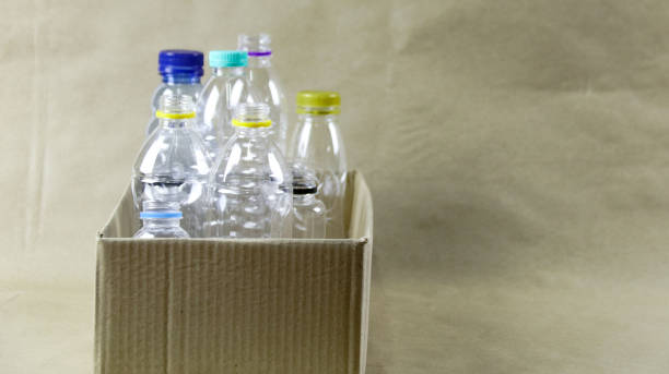istock Plastic bottles in a box on a brown surface, awaiting recycling. 2162256748