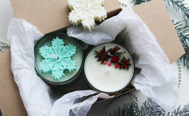 handmade Christmas candles made of natural soy wax and fir branches with Christmas tree decorations