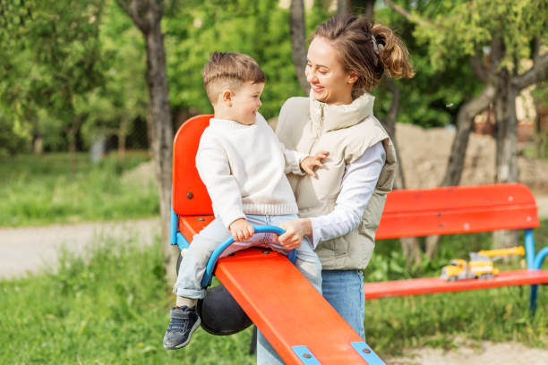 istock Mom and Son Laughing on Seesaw. Playtime. 2162259029