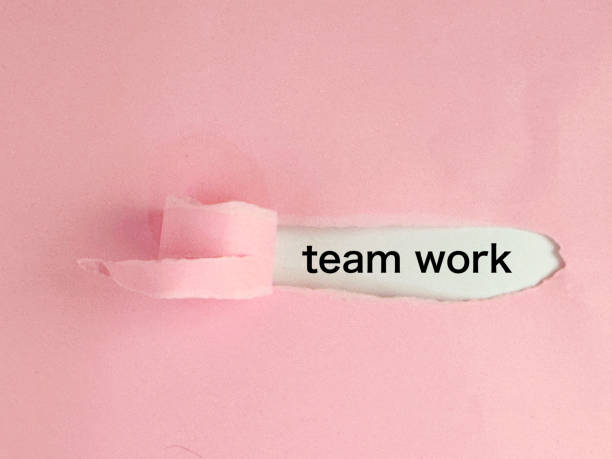 istock team work appearing behind the torn paper 2162259289