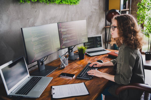 istock Photo of confident successful young woman hacker software developer sitting armchair comfortable workstation indoors 2162259955