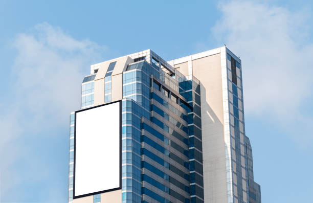 istock Mock up white vertical large LED display billboard on tower building with blue sky background .clipping path for mockup 2162260493