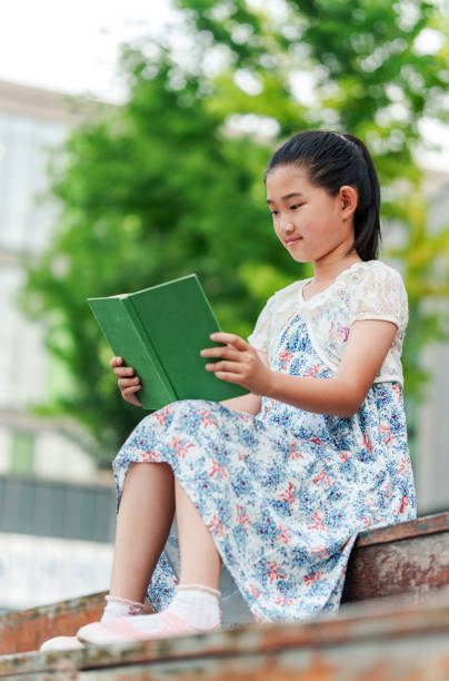 istock Little Girl Reading Book 2162261327