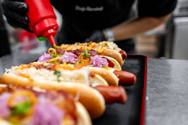 Chef hand cooking set hot dog on kitchen