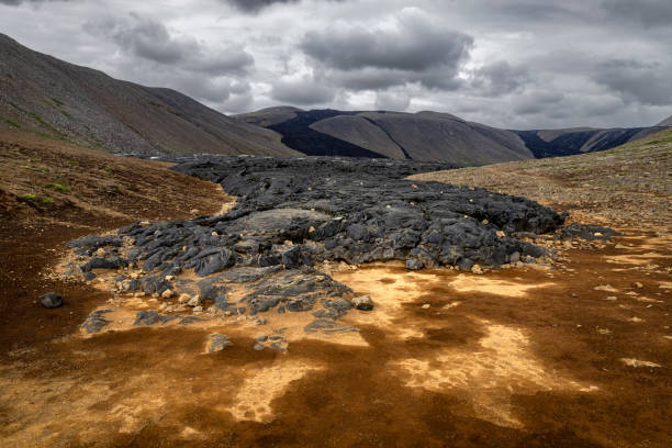 Black lava rocks flowing through a mountain valley in iceland