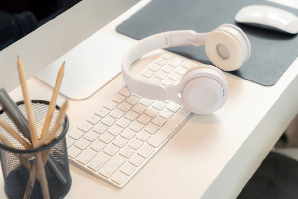 Wireless headphones are placed on a computer at home