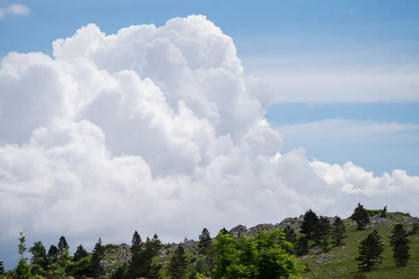 istock A mighty white cloud appears behind a mountain ridge. 2162273043