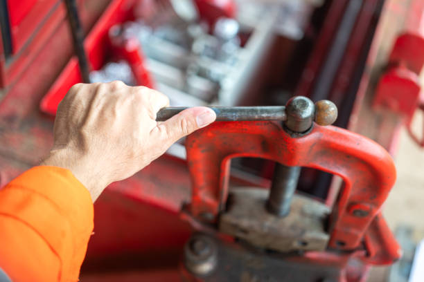 A repairman is using the pipe vise grip that installed on toolbox. Industrial working action scene,  close-up and selective focus.