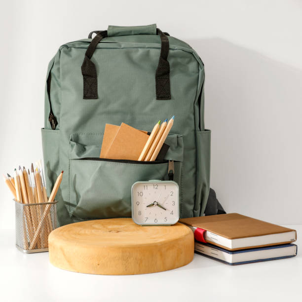 istock School backpack and school stuff with space for products on light grey wall background. 2162274142
