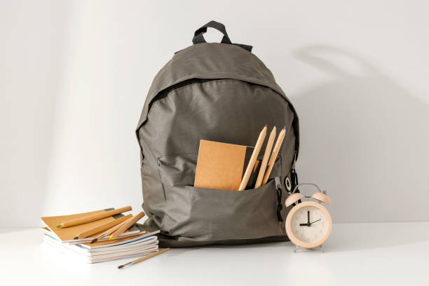 istock School backpack and school stuff with space for products on light grey wall background. 2162274183