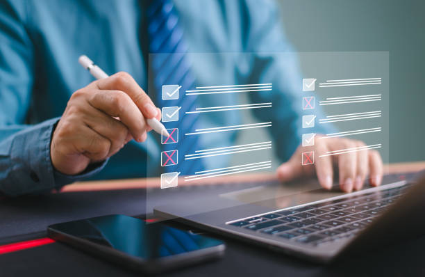 istock Check business checklist performance concept. Businessman use computer laptop tick online checklist. Mobile phone survey, fill digital task, data assessment list, questionnaire, evaluate audit, exam. 2162275025