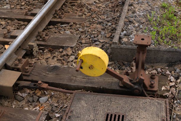 A yellow switch mechanism is located between two railway tracks, indicating a point where the tracks can be switched.