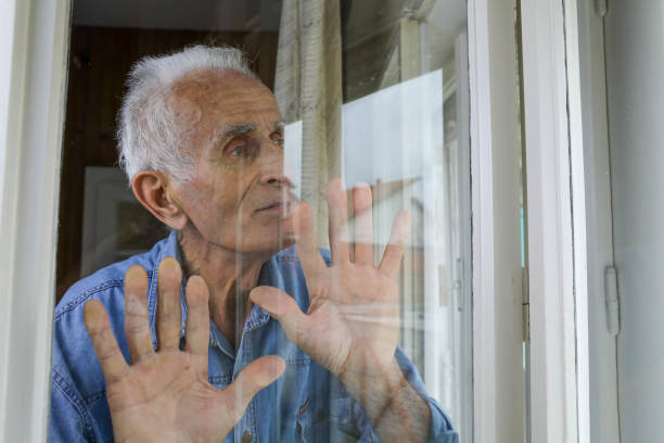 istock Elderly Man in Blue Denim Shirt Gazing Out Window in Thoughtful Reflection 2162281996