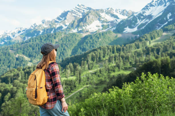 istock Young woman hiker in cap with yellow backpack on background of mountain range Active lifestyle Copy space 2162284005
