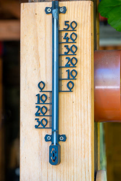 a wooden thermometer with a black handle and a black scale