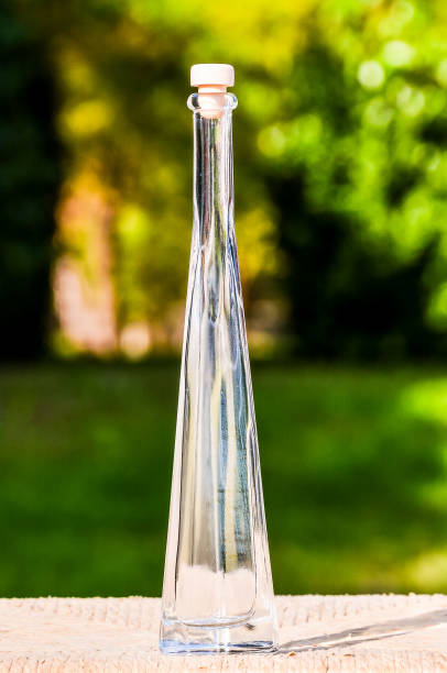 istock A tall, clear bottle with a cork stopper sits on a wooden table 2162298511