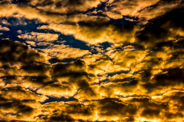 The sky is filled with clouds and the sun is setting