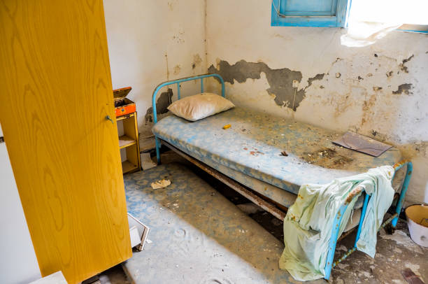 istock A dirty, broken bed with a yellow door and a blue sheet 2162302801