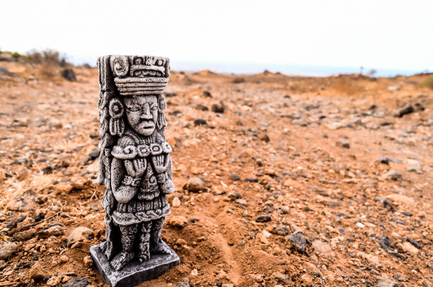 A statue of a man stands in the desert. The statue is made of stone and is very tall. The desert is barren and rocky, with no vegetation in sight