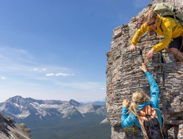 istock Climber offers helping hand to friend 2162308937