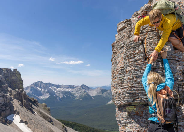 istock Climber offers helping hand to friend 2162308990