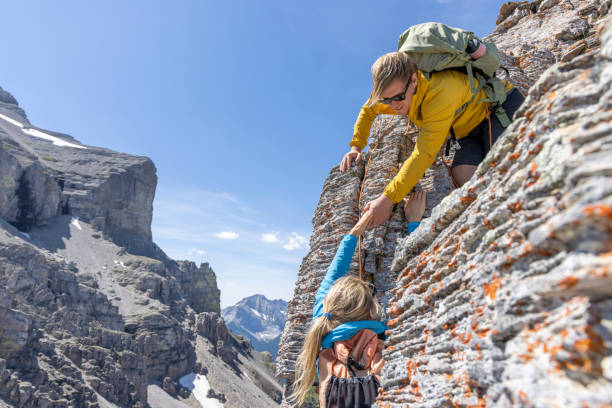 two little girls sisters twins climbing on rock together outside, lifestyle people concept