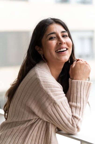 istock Beautiful young woman smiling leaning on railing at home 2162309302