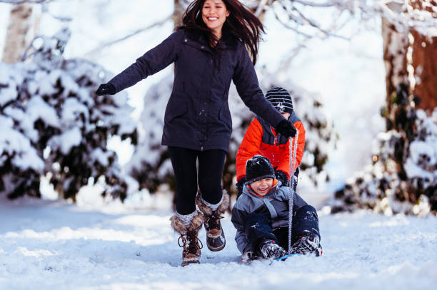 istock Mother pulls son on a sled in the snow 2162312961