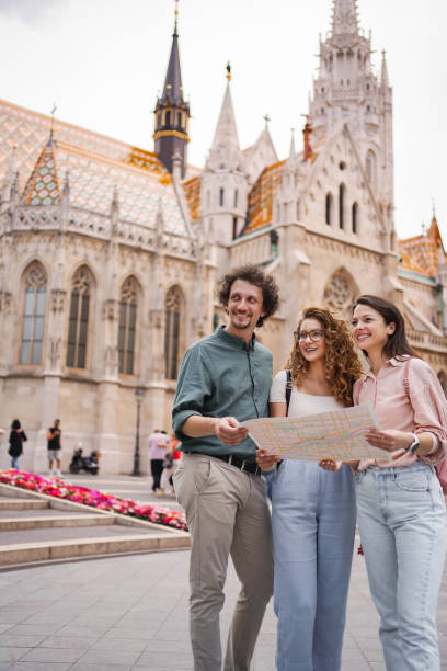 istock Group of friends exploring Budapest while looking at a map near a historic building 2162313473