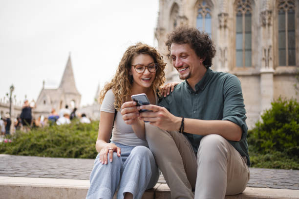 istock Couple enjoying time together while checking a smartphone in Budapest near historic architecture 2162313524