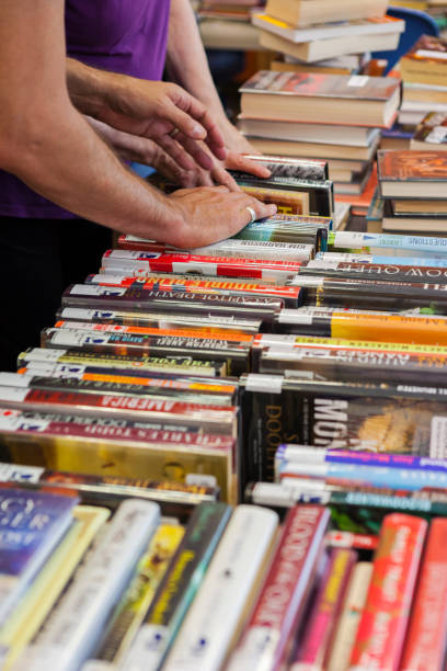 istock People Looking Through Stacks of Used Books 2162318066