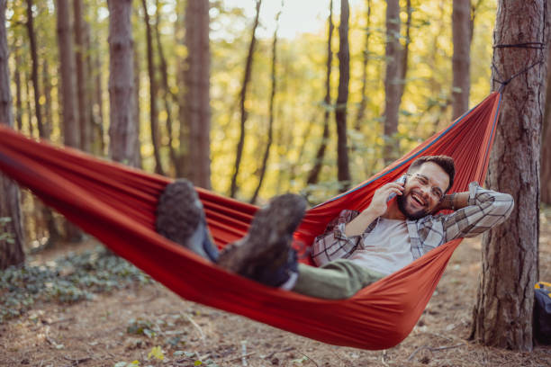 istock Smiling Man in the Hammock Talking on Mobile Phone 2162319369