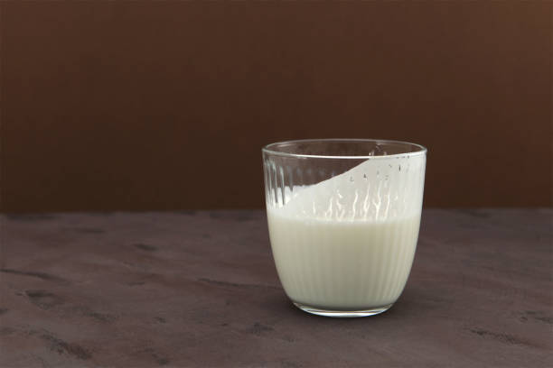 Ayran or Kefir on brown background, side view. Buttermilk made with yogurt. Fermented sour milk. Milk diet for weight loss.