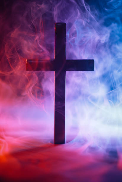 istock Religious cross surrounded by red and blue smoke symbolizing Heaven and Hell, good and evil, right and wrong, or other metaphor for moral choices. 2162326363