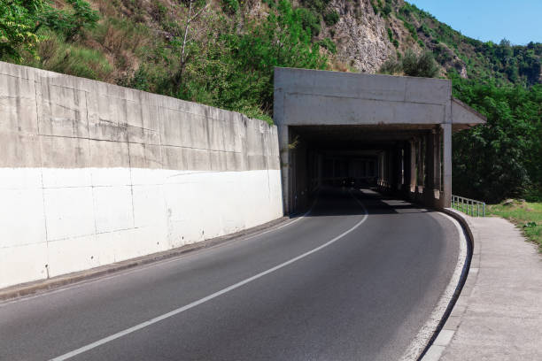 Asphalt road under the bridge in the mountains in Montenegro.  Tunnel leading to unknown destination